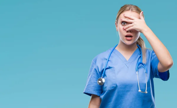 Jovem Cirurgiã Loira Médica Mulher Sobre Fundo Isolado Espreitando Choque — Fotografia de Stock