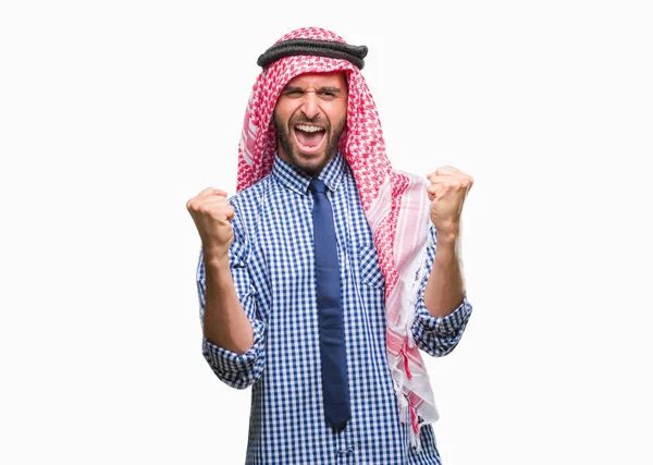 若いハンサムなアラビアン ビジネス男非常に幸せと興奮の腕を上げ 勝者のジェスチャを行う分離の背景にクーフィーヤを着て笑顔で成功のために叫んで お祝いのコンセプト — ストック写真