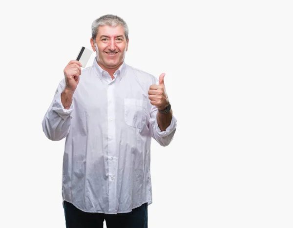 英俊的老人拿着信用卡在孤立的背景高兴与灿烂的微笑做确定的标志 用手指竖起大拇指 优秀的标志 — 图库照片