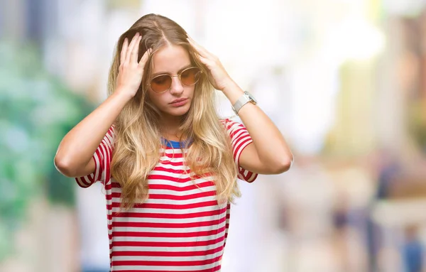 年轻美丽的金发女子戴墨镜在孤立的背景下患有头痛绝望和强调 因为疼痛和偏头痛 手在头上 — 图库照片