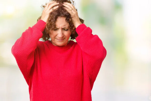 美丽的中间年龄的老年妇女红色冬季毛衣在孤立的背景遭受头痛绝望和压力 因为疼痛和偏头痛 双手放在头上 — 图库照片