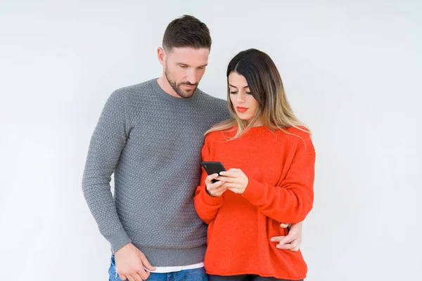 Pareja Joven Que Utiliza Teléfono Inteligente Sobre Fondo Aislado Con —  Fotos de Stock