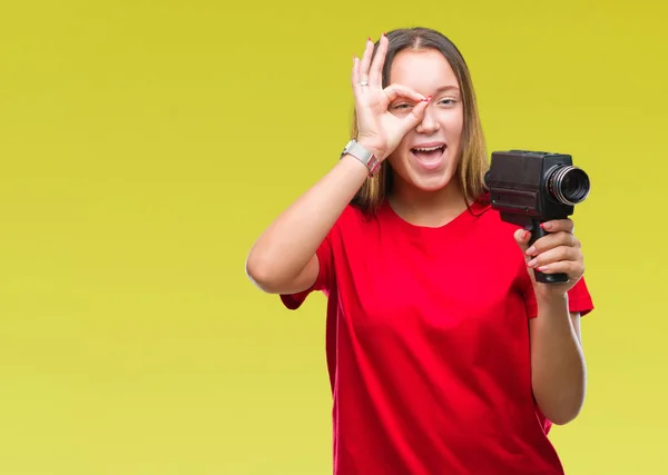ビンテージ カメラを使った撮影若い美しい白人女性が指を通して見る目に手で サインをして笑っている幸せそうな顔で背景を分離 — ストック写真