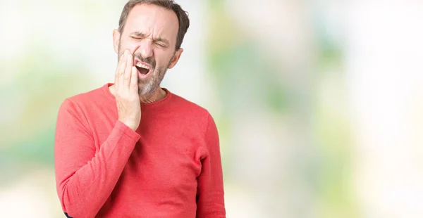 ハンサムな中年白髪シニア男性歯痛や歯の歯科病気のため痛みを伴う式で手で口に触れて分離の背景に冬のセーターを着ています 歯医者コンセプト — ストック写真