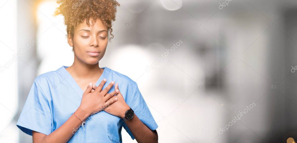 Young african american doctor woman over isolated background smiling with hands on chest with closed eyes and grateful gesture on face. Health concept.