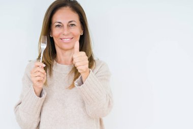 Orta yaş kadın gümüş çatal metal holding ok işareti, başparmak ile parmak, mükemmel işareti yapıyor kocaman bir gülümseme ile arka plan mutlu izole