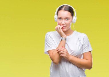 Tırnak ısırma dudaklarından eller genç beyaz kadın müzik giyen kulaklık için stresli ve gergin ile izole arka plan üzerinde dinleme. Anksiyete sorunu.