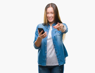 Kamera ve size parmak ile işaret arka plan üzerinde Smartphone kullanarak ileti gönderme genç güzel beyaz kadın manifatura izole, el işareti, pozitif ve kendinden emin bir jest ön