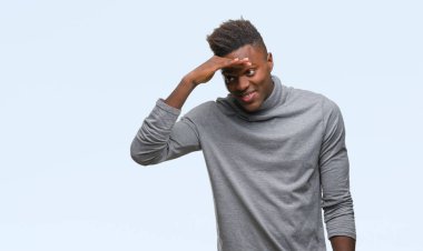 Afrikalı-Amerikalı genç izole arka plan çok mutlu ve gülümseyen uzakta el ile üzerine kafa seyir üzerinde. Arama kavramı.