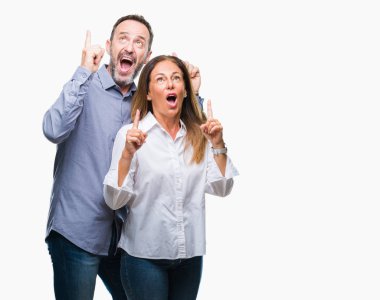 Orta yaş İspanyol iş çift izole arka plan üzerinde hayret ve yukarıya bakıp parmakları ile işaret şaşırttı ve silah kaldırdı.