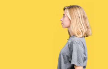 İzole arka tarafına, seyir üzerinde büyük boy rahat t-shirt giyen güzel genç kadın dinlenmek doğal yüz emin gülümseme ile pozuyla profili.