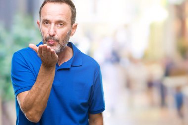 Orta yaş bir öpücük el ile güzel ve seksi olmak hava üfleme kamera bakarak izole arka plan üzerinde ağarmış komuta sizde. Aşk ifade.