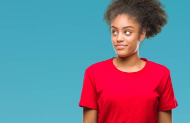 Genç afro Amerikalı kadın görünümlü yan ve dik dik bakma uzağa düşünce gülümseyen izole arka plan üzerinde.