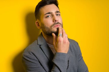 Yakışıklı delikanlı possing ve izole sarı arka plan üzerinde modelleme