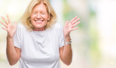 Orta yaş sarışın kadın deli ve silah ile başarı için deli kutluyor izole arka plan üzerinde kaldırdı ve heyecanlı çığlık gözler kapalı. Kazanan kavramı