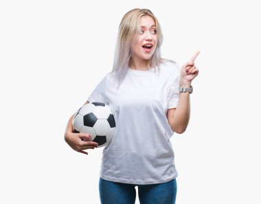 Futbol futbol topu izole arka plan üzerinde çok mutlu el ve parmak ile tarafına işaret tutan genç sarışın kadın
