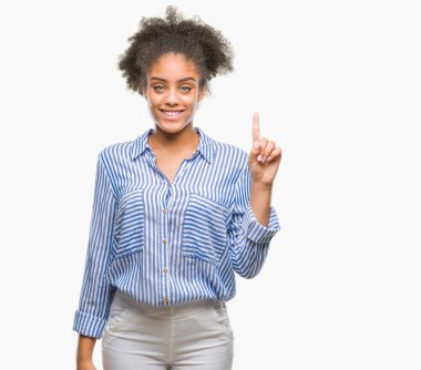 Genç afro Amerikalı kadın ve kendinden emin ve mutlu gülümseyerek süre parmak numaralı yukarıyı gösteren izole arka plan üzerinde.