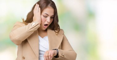 Artı boyutu genç kadın izole arka plan üzerinde kış ceket giyen güzel seyretmek zaman arıyorsunuz, korkmuş-in geç endişeli