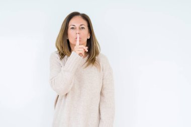 Dudaklarında parmak ile sessiz olmanı izole arka plan güzel orta yaş kadın. Sessizlik ve gizli kavramı.