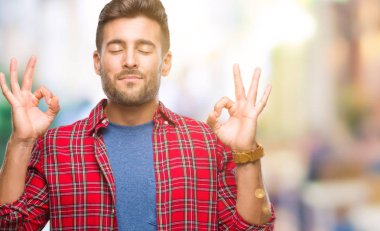 Yakışıklı delikanlı izole arka plan üzerinde dinlenmek ve gülümseyen gözlerle parmak ile meditasyon jest yapıyor kapalı. Yoga kavramı.