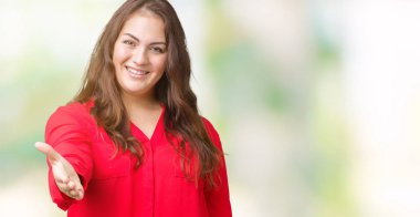 Artı boyutu genç iş kadını olarak tebrik ve konuksever dost sunan karşılıklı gülümseyen izole arka plan üzerinde güzel. Başarılı iş.