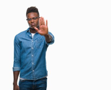 Afro-Amerikan delikanlı dur yapıyor izole arka plan üzerinde şarkı elin avuç ile. Negatif ve ciddi bir jest yüz ifadesiyle uyarı.
