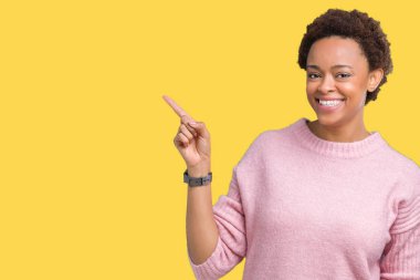 Yüzünde kocaman bir gülümseme ile izole arka plan üzerinde güzel genç Afro-Amerikan kadın kameraya bakarak yan el ve parmak ile işaret.