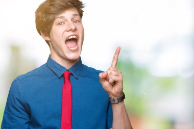 Genç yakışıklı iş adamı ile başarılı fikir izole arka plan işaret parmağı üzerinde kırmızı kravat takıyor. Çıktıktan ve mutlu. Bir numara.