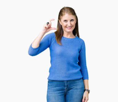 İzole arka plan gülümseyen ve boyutu işaret parmaklı ararken ve kamera işi el ile kendinden emin eller üzerinde kış kazak giyen güzel orta yaş Olgun kadın. Ölçü kavramı.