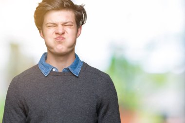 Genç yakışıklı zarif adam komik surat ile yanakları şişirme izole arka plan üzerinde. Ağız ile hava, deli ifade şişirilmiş.