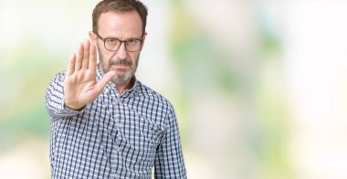 Yakışıklı orta yaş zarif üst düzey iş adam gözlük stop yapıyor izole arka plan üzerinde elin avuç ile şarkı. Negatif ve ciddi bir jest yüz ifadesiyle uyarı.