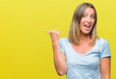 Seyir ve başparmak yanında yukarıyı mutlu yüz ile gülümseyen izole arka plan üzerinde genç güzel kadın.