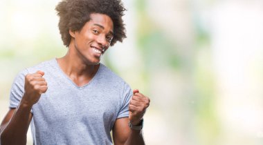 Gülümseyen ve başarı için çığlık Afro Amerikan adam izole arka plan çok mutlu ve heyecanlı kaldırdı, silah ile kazanan jest yapıyor. Kutlama kavramı.
