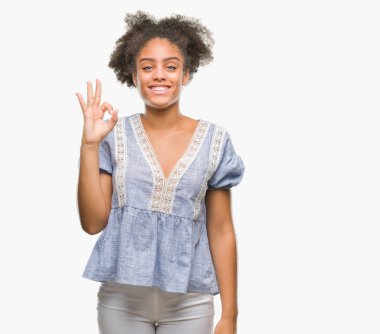 Gülümseyen izole arka plan üzerinde genç afro Amerikalı kadın el ve parmaklar ok işaretiyle yapıyor olumlu. Başarılı ifade.