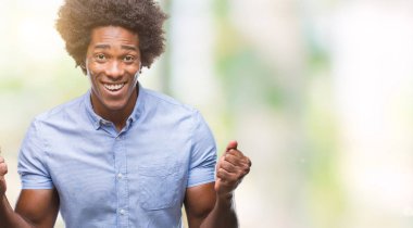 İzole arka plan kutlama üzerinde Afro Amerikalı adam şaşırttı ve başarı için kaldırdı kollarını açarak hayret ve gözleri açık. Kazanan kavramı.