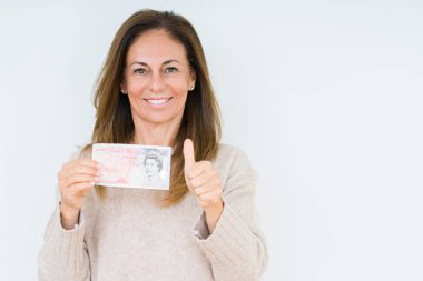 İzole arka plan üzerinde 50 pound banknot ok işareti, başparmak ile parmak, mükemmel işareti yapıyor kocaman bir gülümseme ile mutlu tutan orta yaş kadın