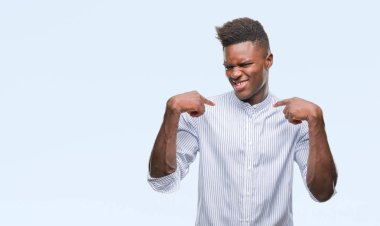 Yüzünde gülümseme ile kendinden emin görünüyorsun, kendini gururlu ve mutlu parmakları ile işaret izole arka plan üzerinde genç Afro-Amerikan adam.