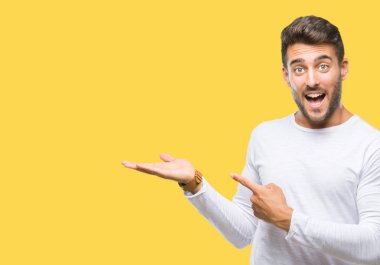 Yakışıklı delikanlı üzerinden hayran ve el ile sunulması ve parmak ile işaret ederken kameraya gülümseyen izole arka plan.