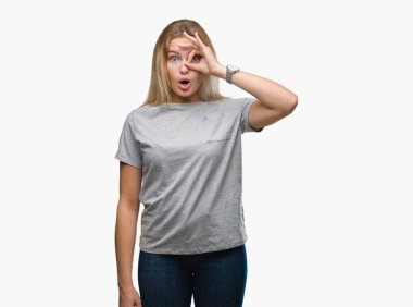 Sürpriz yüz, göz parmaklarının arasından seyir ile ok jest yapıyor izole arka plan üzerinde beyaz kadın şok. İmansız ifade.