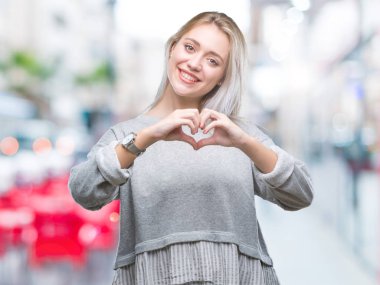 Genç Sarışın kadın kalp simgesi ve elleriyle şekil gösterilen aşık gülümseyen izole arka plan yüzünden. Romantik kavramı.