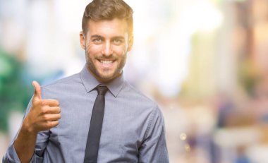 Genç yakışıklı iş adamı mutlu yaşasın el ile jest yapıyor izole arka plan üzerinde. Kameraya bakarak başarı gösteren ile ifade onaylama.