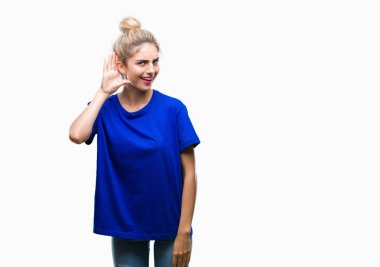 Bir işitme söylenti ya da dedikodu için dinleme kulak üzerinde el ile gülümseyen izole arka plan üzerinde mavi t-shirt giyen genç güzel sarışın ve mavi gözlü kadın. Sağırlık kavramı.