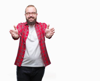 Sarılmak için kollarını açarak gülümseyerek kameraya bakarak izole arka plan üzerinde gözlük takan Genç beyaz hipster adam. Neşeli ifade kucaklayan mutluluk.