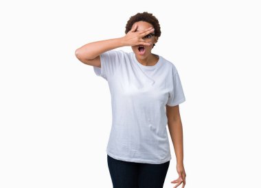 Mahcup ifadeyle parmaklarımın arasından yüz ve gözler el ile kapsayan şok bakmak izole arka plan üzerinde gözlük güzel genç Afro-Amerikan kadın arıyor.