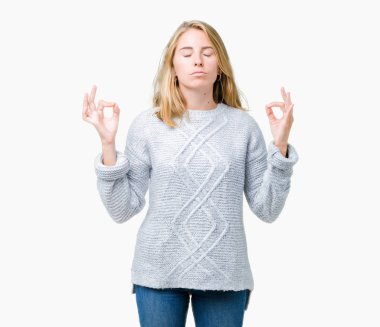 Güzel genç kadın giyiyor kış kazak izole arka plan üzerinde dinlenmek ve gülümseyen gözlerle kapalı parmak jestle meditasyon yapıyor. Yoga kavramı.