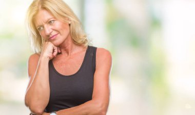 Orta yaş sarışın kadın izole arka plan düşünme seyir üzerinde yorgun ve sıkılmış çapraz silah depresyon sorunları ile.