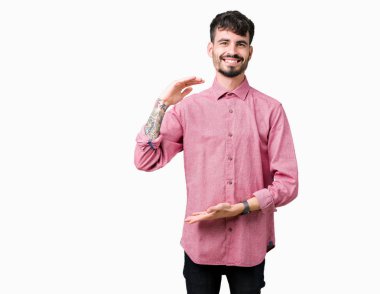 Büyük ve büyük boy işaret, ölçü birimi sembol gösteren ellerle eller izole arka plan üzerinde pembe gömlek giymiş yakışıklı delikanlı. Kameraya bakarak gülümsüyordu. Ölçüm kavramı.