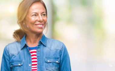 İzole arka plan uzak tarafına gülümseme ile yüzünde, doğal ifade seyir üzerinde orta yaş İspanyol kadın kıdemli. Kendine güvenen gülüyor.