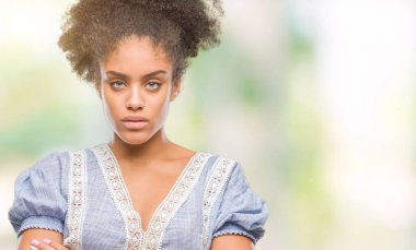 Genç afro Amerikan kadın izole arka plan şüpheci ve çapraz kolları olan yüzündeki gergin, onaylamayan ifade yüzünden. Negatif kişi.
