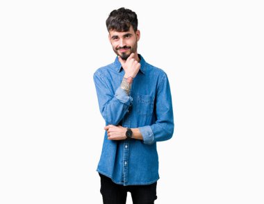 Yakışıklı delikanlı emin çapraz kollar ve çeneme kaldırdı el ile gülümseme ile kameraya bakarak izole arka plan üzerinde. Pozitif düşünce.